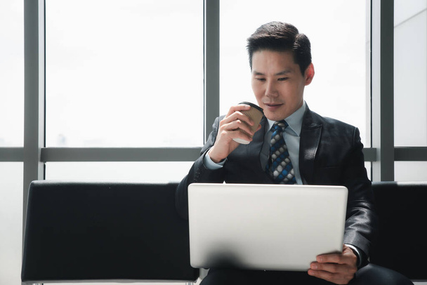 asian businessman working with laptop and drinking coffee - Zdjęcie, obraz