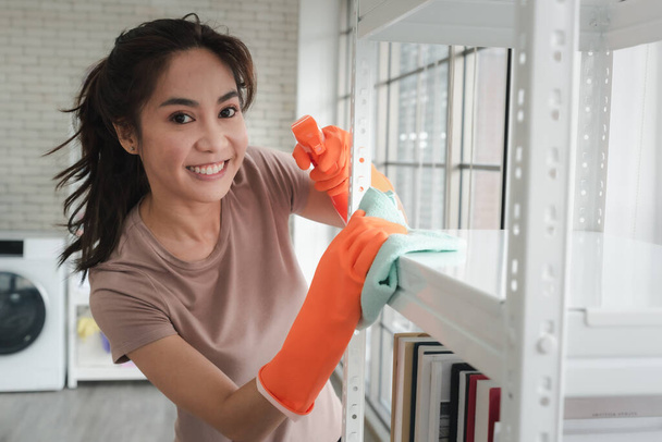 young woman with cleaning supplies cleaning in home  - Foto, imagen