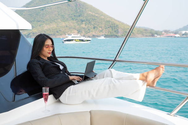 Aziatisch jong zakenvrouw met laptop op het jacht in de zomer - Foto, afbeelding