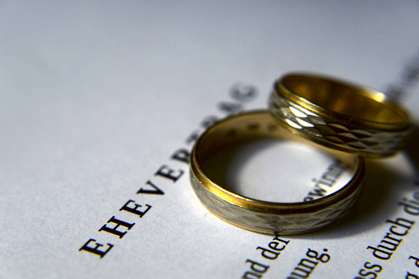 A prenuptial agreement and two wedding rings - Photo, Image