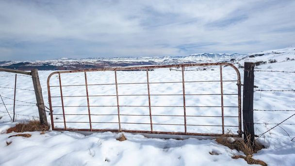 山の冬の雪のファームゲートを閉じる風光明媚なパノラマの風景を対照的に. - 写真・画像