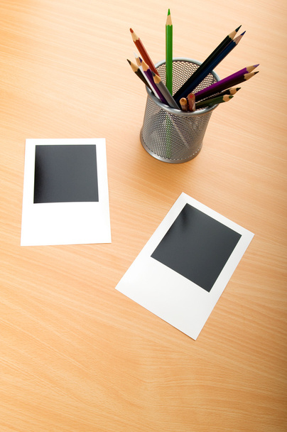 Fotos instantáneas en blanco y lápices en la mesa de madera
 - Foto, Imagen