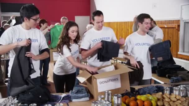 Freiwillige sortieren gespendete Waren - Filmmaterial, Video