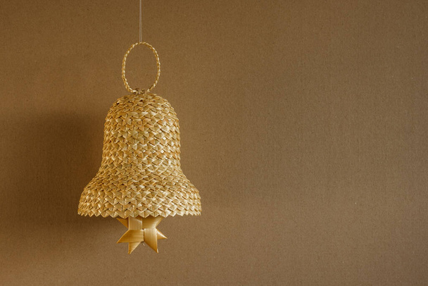 Bell made out of straw on a beige background. Straw bells decorations. Copy space. Background - Foto, Imagem
