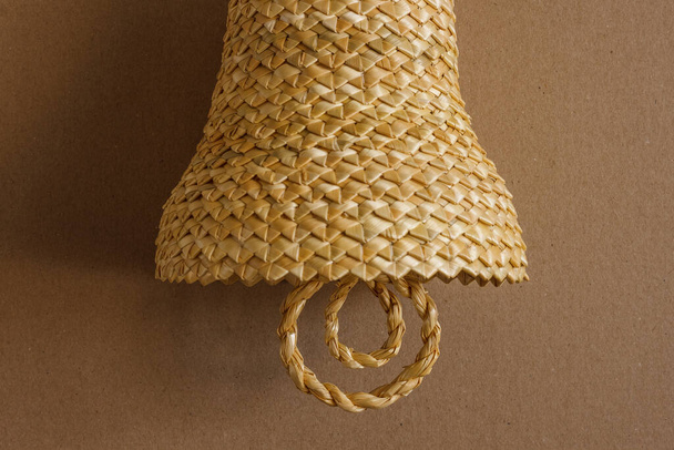 Bell made out of straw on a beige background. Straw bells decorations.  Background - Photo, Image