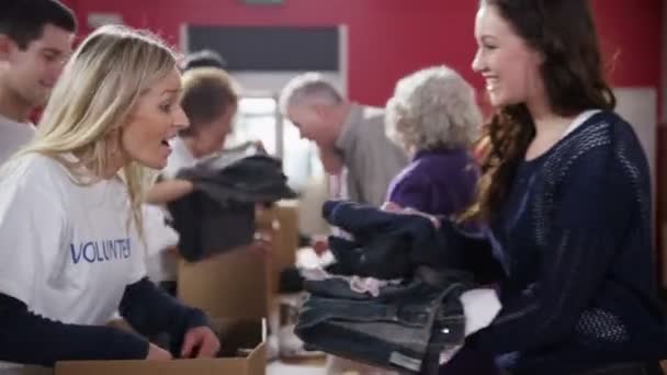 liefdadigheid werknemers accepteren donaties van voedsel en kleding uit leden van de Gemeenschap - Video