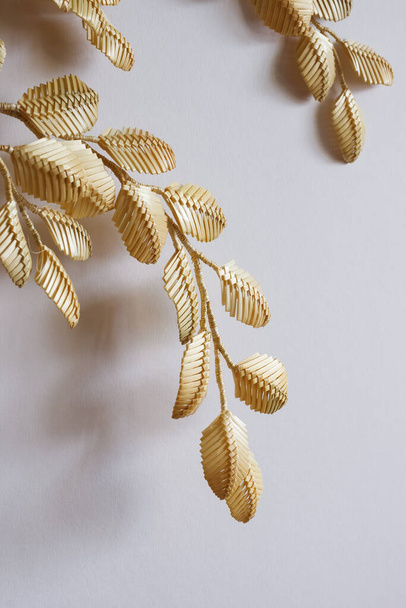Decoration of straw on a white background. Branch with leaves is made of straw. Decor. Fragment closeup. - Photo, Image