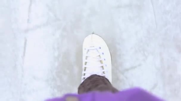 Un uomo pattina su una pista di pattinaggio, vista in prima persona delle sue gambe dall'alto. Sport invernali, divertimento invernale - Filmati, video
