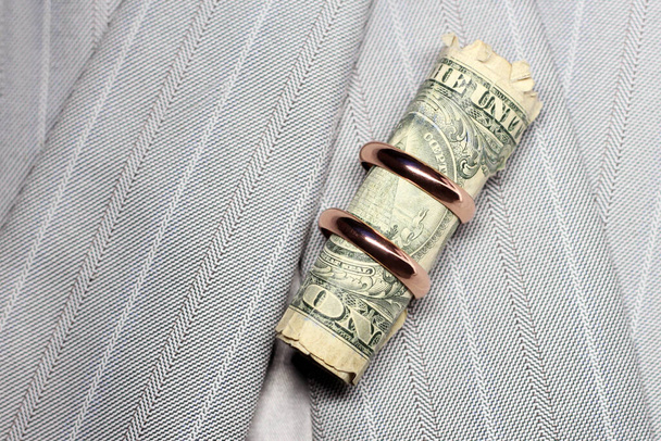Svatební prsteny a peníze na šedé bundě - Fotografie, Obrázek