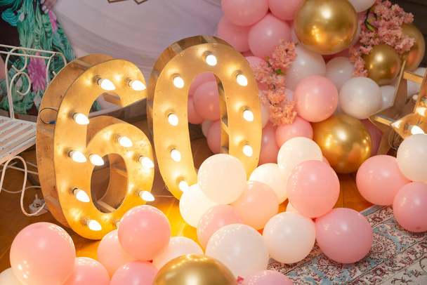 Χρόνια πολλά! Διακόσμηση για εξήντα ετών. Ροζ μπαλόνια και φώτα. - Φωτογραφία, εικόνα