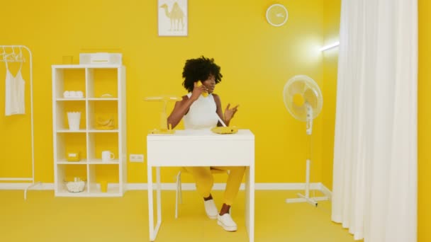 Mujer mandona está hablando de teléfono en amarillo Oficina Creativa - Imágenes, Vídeo