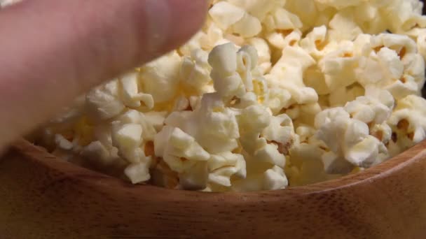 popcornia kulhoon vie käsi lähikuva. valikoiva kohdentaminen. katsot elokuvaa - Materiaali, video