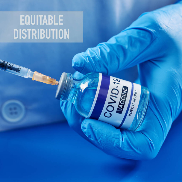 closeup of a person, wearing white coat and blue surgical gloves, filling a syringe from a simulated vial of covid-19 vaccine, and the text equitable distribution - Photo, Image