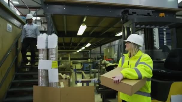 Los trabajadores en un almacén con un ordenador portátil están preparando las mercancías para la entrega
 - Metraje, vídeo
