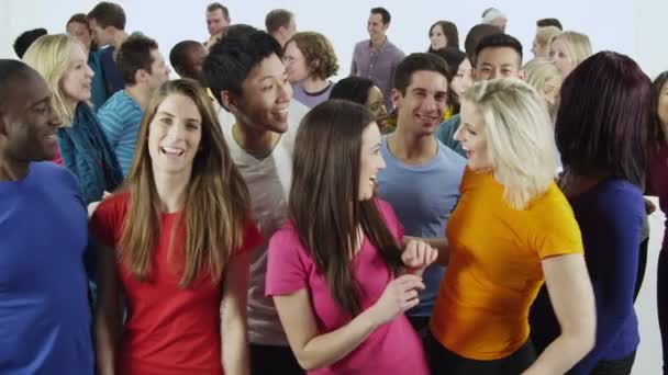 Багато етнічних груп людей, що стоять разом у яскраво-кольоровому повсякденному одязі та розважаються
 - Кадри, відео