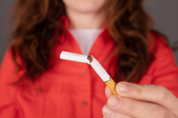 Kadın elinde kırık sigara, nikotin bağımlılığı. - Fotoğraf, Görsel