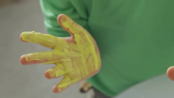 Pintura con pintura amarilla y azul en manos de niños - Metraje, vídeo