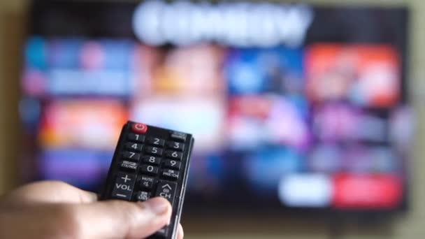lähikuva mies käsi tilalla tv kaukosäädin ja television katselun - Materiaali, video