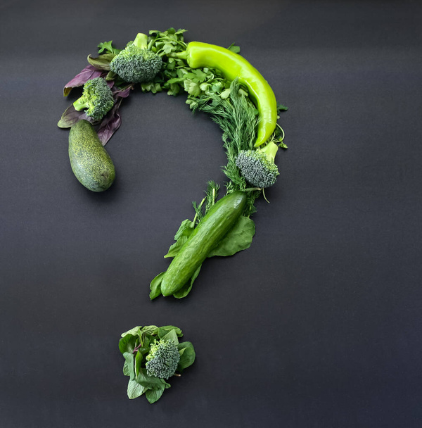 Légumes verts en forme de point d'interrogation sur fond noir - Photo, image