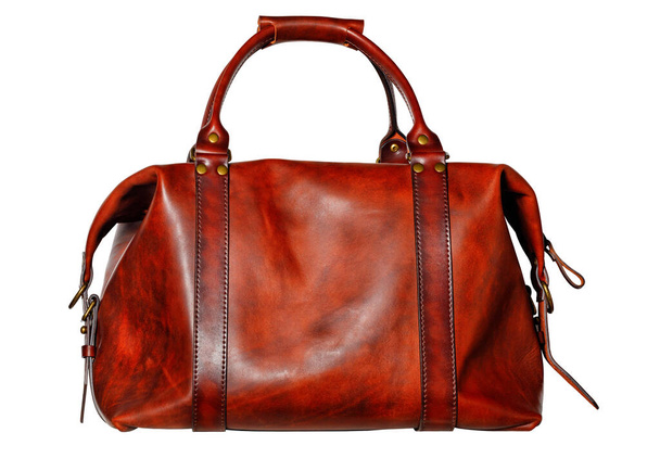 Krásná červená a hnědá kožená taška s postranními zapínadly, popruhy a mosaznými přezkami ve stylu vintage na bílém pozadí. - Fotografie, Obrázek