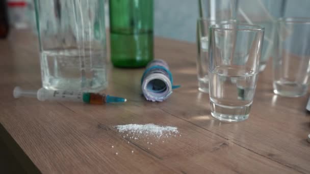 mies tuo kourallinen pillereitä pöydälle alkoholin ja huumeiden kanssa - Materiaali, video