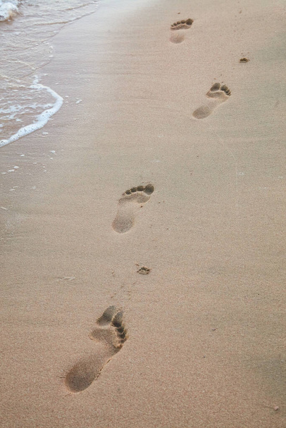 Foot prints on the beach of a seashore near the sea - Zdjęcie, obraz