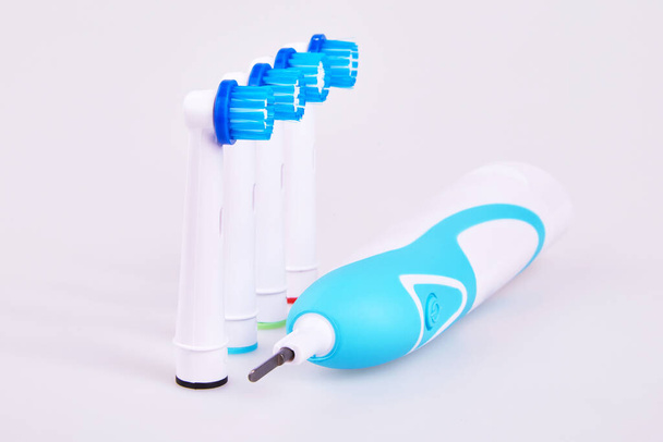 Запчастини для електричної зубної щітки на білому тлі. Така щітка очищається набагато ефективніше, ніж звичайна зубна щітка
. - Фото, зображення
