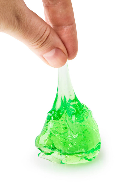 Una mano sosteniendo un limo verde transparente aislado en blanco con el camino de recorte. Juguete transparente pegajoso moderno - Foto, Imagen