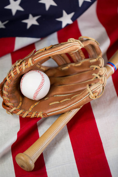 Honkbalknuppel en handschoen op Amerikaanse vlag - Foto, afbeelding