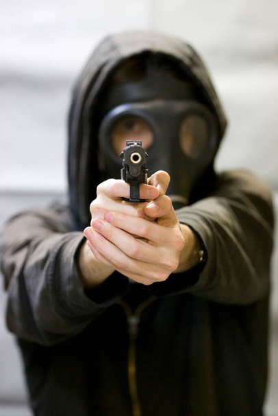 Озброєний чоловік в светрі вказує на пістолет
 - Фото, зображення