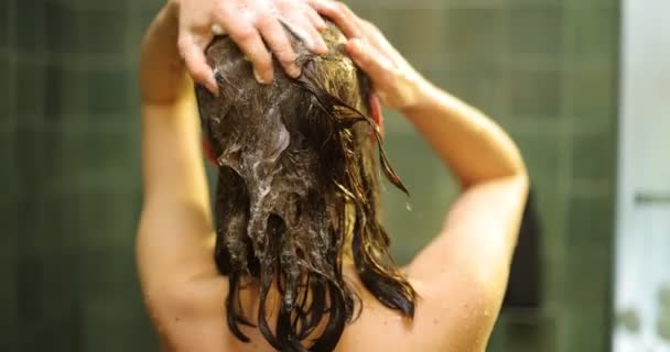 Duşta saç yıkayan bir kadın. - Video, Çekim