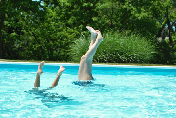 Madre e hija haciendo puestos de manos en la piscina - Foto, imagen