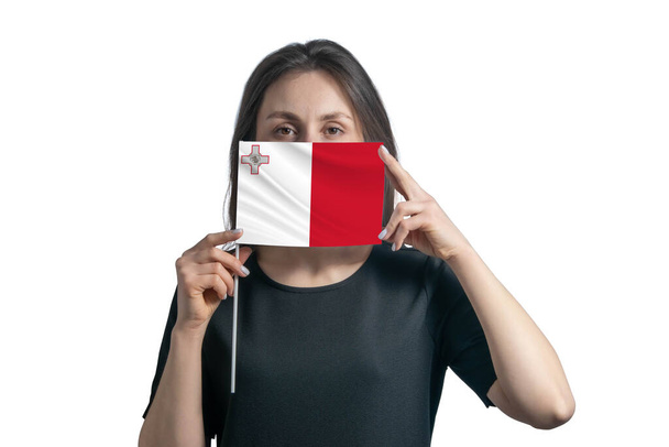 Щаслива молода біла жінка, що тримає прапор Мальта і закриває обличчя ізольованим на білому тлі.. - Фото, зображення