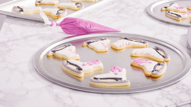 Icing figure skate shaped sugar cookies with royal icing. - Photo, Image