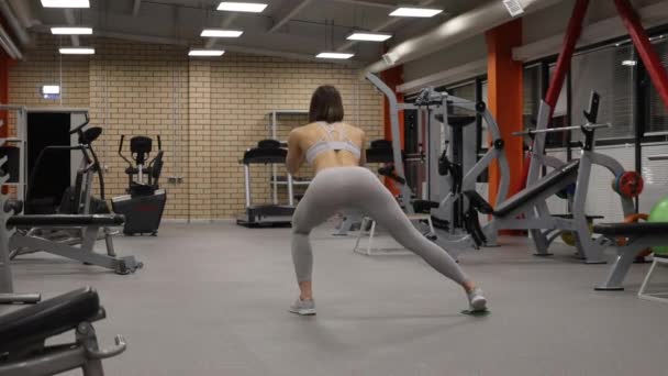 Sportif kadın ısınıyor ve spor salonunda antrenman yapıyor. - Video, Çekim