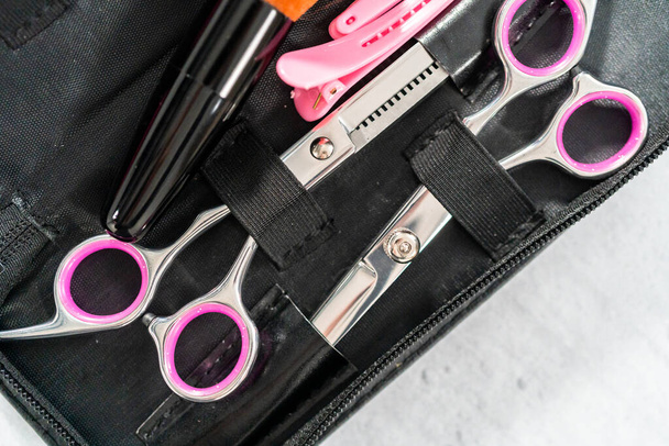 New barber set with pink scissors on a gray background. - Photo, Image