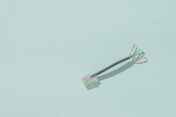 Vetkőzött UTP kábel egy tipp egy világoskék háttér. Ethernet-hálózat összekapcsolására szolgáló anyagok. - Fotó, kép