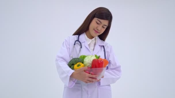 Arzt oder Ernährungsberater halten frisches Obst in der Hand und lächeln in einer Klinik. Gesunde Ernährung Konzept der Ernährung Lebensmittel als Rezept für eine gute Gesundheit, die Frucht ist Medizin - Filmmaterial, Video