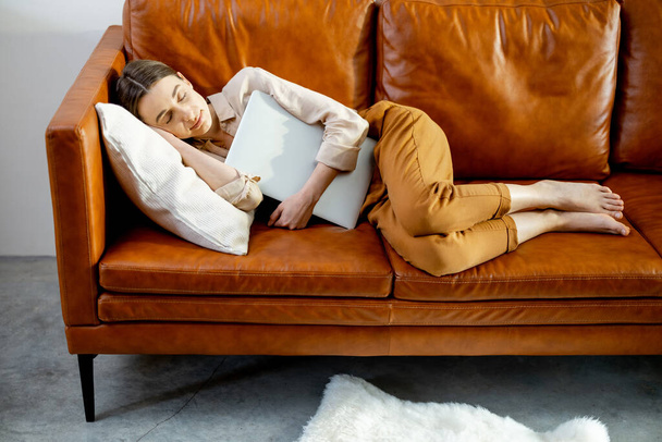 Η γυναίκα αποκοιμήθηκε στον άνετο καφέ καναπέ.. - Φωτογραφία, εικόνα