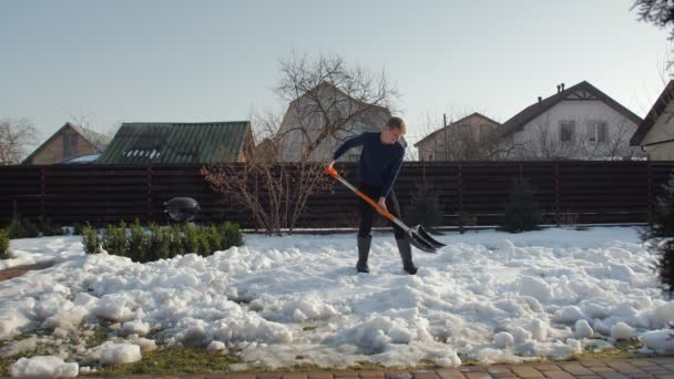 Человек чистит снег лопатой - Кадры, видео
