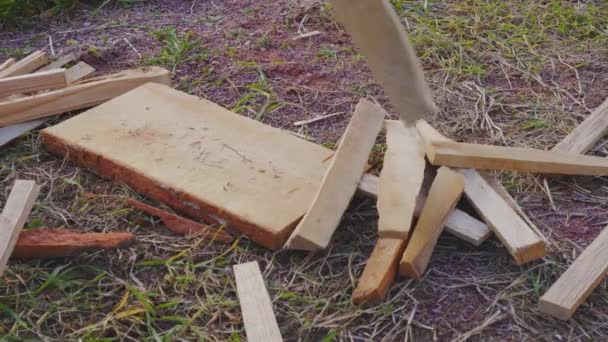 Ein Mann hackt Holz in kleine Späne, um ein Feuer zu entzünden, um ein Haus zu heizen. Der Alltag der einfachen Leute in einem Landhaus - Filmmaterial, Video