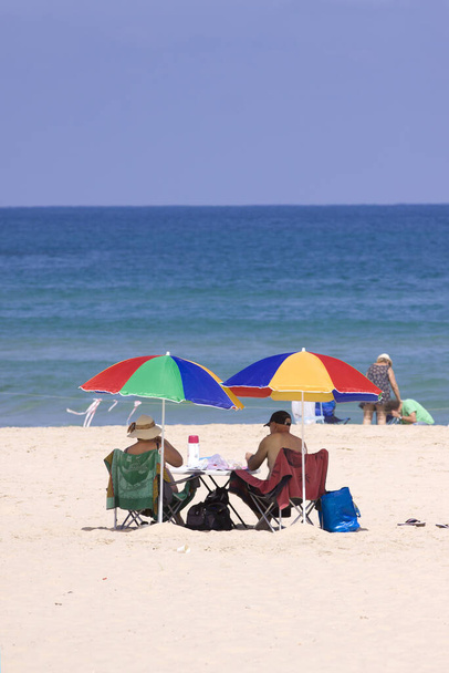 Playa verano pareja bajo paraguas - Foto, Imagen