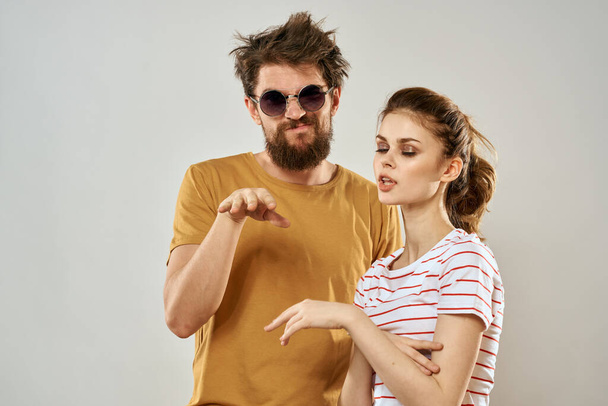 hombre en gafas de sol junto a mujer en camiseta rayada emociones comunicación estudio de moda diversión - Foto, imagen