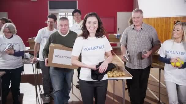 Velká skupina dobrovolníků, charitativní shromáždit a dát velký úsměv do kamery - Záběry, video