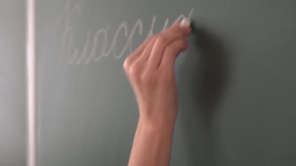 Professeur d'école écrit à la craie sur le tableau noir de classe - Séquence, vidéo