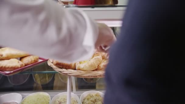 tevreden klanten kopen koffie en vers gebak in een café - Video