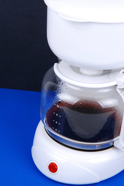 A white coffee maker wit fresh coffee, sitting on royal blue fabric for black background, closeup picture. - Photo, Image