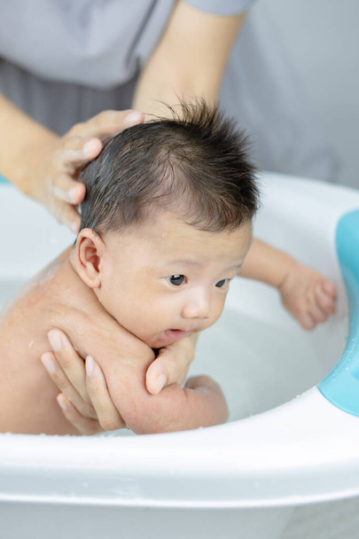 Äiti pesee hänen pieni vauva poika kylvyssä       - Valokuva, kuva