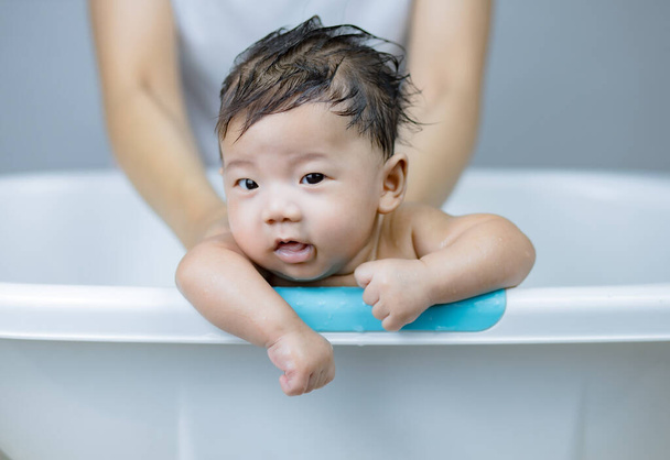 Pequeno bebê tomando banho nas mãos das mães - Foto, Imagem