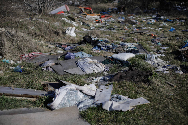 Bucharest, Romania - March 3, 2021: Garbage and construction debris scattered all around an empty lot in Bucharest, near a makeshift shelter. - Photo, Image